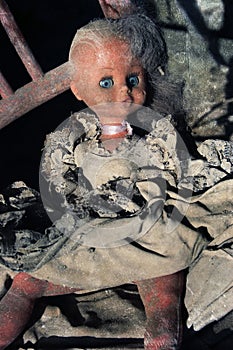 Diabolical doll sitting on an old chair