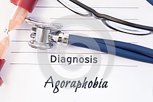 Diagnosis Agoraphobia. Psychiatric diagnosis Agoraphobia is written on paper, on which lay stethoscope and hourglass for measuring photo