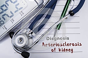 Diagnosis arteriosclerosis of kidney. Stethoscope and electronic sphygmomanometer lie on medical paper form with cardiac diagnosis photo
