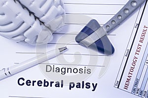 Diagnosis Cerebral palsy. Figure brain, neurological hammer, printed on a paper blood test and written diagnosis of Cerebral palsy photo