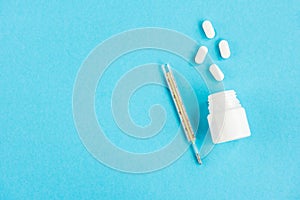 Diagnosis of the disease. Notebook with pen and pills on a blue background