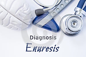 Diagnosis of Enuresis. Anatomical brain figure, neurological hammer and stethoscope lying on sheet of paper or book with the title