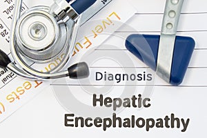 Diagnosis Hepatic Encephalopathy. Neurological hammer, stethoscope and liver laboratory test lie on note with title of Hepatic Enc photo