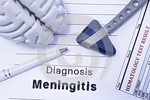 Diagnosis meningitis. Figure brain, neurological hammer, printed on a paper blood test and written diagnosis of meningitis in the photo