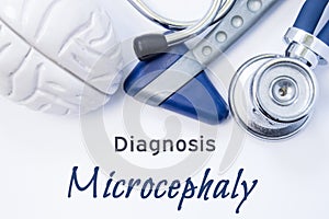 Diagnosis of Microcephaly. Anatomical brain figure, neurological hammer and stethoscope lying on sheet of paper or book with the t