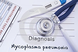 Diagnosis of Mycoplasma Pneumonia. Stethoscope, electronic thermometer, blood test results are on medical form, which indicated di photo
