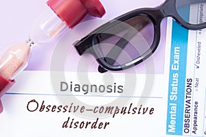 Diagnosis of Obsessive Compulsive Disorder. Hourglass, doctor glasses, mental status exam are near inscription Obsessive-Compulsiv