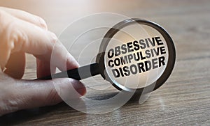 Diagnosis of Obsessive Compulsive Disorder under magnifying glass in hand. Causes, symptoms, diagnosis and treatment of this