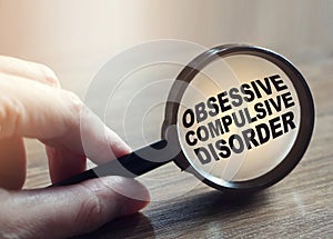 Diagnosis of Obsessive Compulsive Disorder under magnifying glass in hand. Causes, symptoms, diagnosis and treatment of