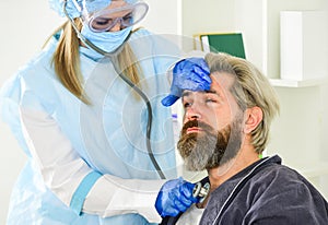 Diagnosis of pneumonia. Sars concept. Doctor protective equipment examines male patient suspected coronavirus infection