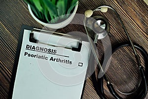 Diagnosis - Psoriatic Arthritis write on a paperwork isolated on Wooden Table