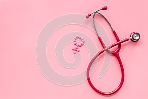 Diagnostic and cure of gynaecological disease with stethoscope and female symbol on pink background top view mock-up