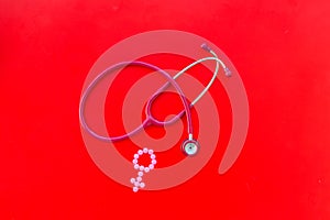 Diagnostic and cure of gynaecological disease with stethoscope and female symbol on red background top view