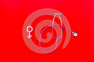 Diagnostic and cure of gynaecological disease with stethoscope and female symbol on red background top view