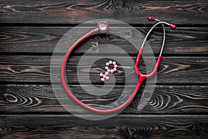 Diagnostic and cure of gynaecological disease with stethoscope and female symbol on wooden background top view