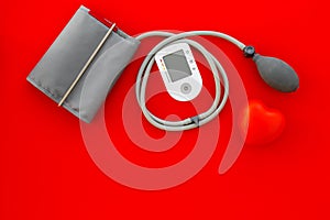 Diagnostics of cardiac disease with pulsimeter on red background top view copyspace