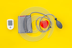 Diagnostics of cardiac disease with pulsimeter on yellow background top view