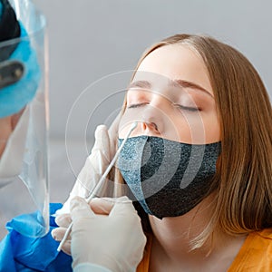 Diagnostics testing patients coronavirus covid 19. Doctor in protective medical mask taking PCR test nasopharyngeal culture to photo