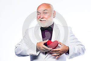 Diagnostics and treatment. Health care. Preventing heart attack. Senior bald head bearded man holding red toy heart in