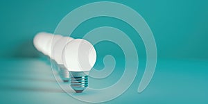 A diagonal arrangement of white light bulbs on a turquoise background, ideal for themes of clarity, simplicity in design