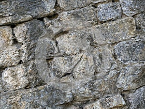 Diagonal background of medieval weathered stones that form a wall.