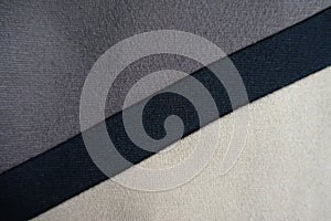 Diagonal black stripe sewn to grey and beige fabric