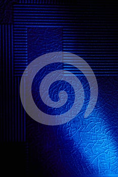 Diagonal bright blue ray of light crosses the background with a pattern