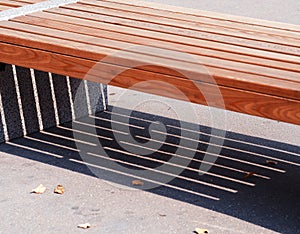 Diagonal city bench with dramatic shadow backdrop