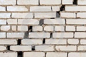 Diagonal crack in a white brick wall, destruction of a brickwork, abstract background
