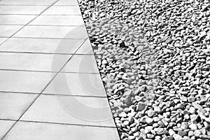 Diagonal dividing line between gray tiles and white gravel