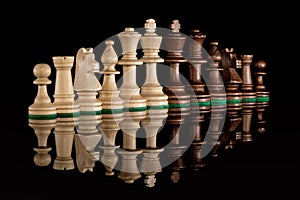Diagonal line of wooden chess pieces isolated at dark background