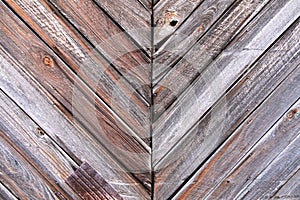 Diagonal lined wood barn door wall siding with visible nails weathered