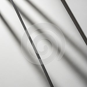 Diagonal lines of light and shadow create a pattern on a textured white surface. The