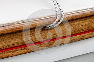 Diagonal Lines Of Shock Cord Rope Coming Out of Varnished Gunnel on a Boat photo