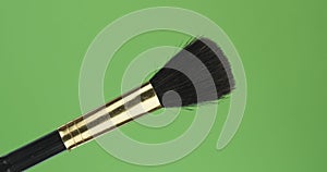 Diagonal rotation of the makeup brush. Isolated on green.