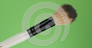 Diagonal rotation of the makeup brush. Isolated on green.