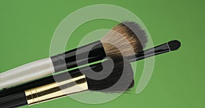 Diagonal rotation of the makeup brushes set. Isolated on green.