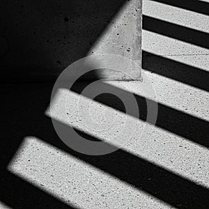 Diagonal shadows cast by a structure create a striking pattern on a textured concrete
