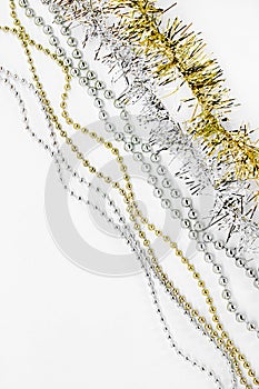 Diagonal silver and golden chain with balls, beads, yellow tinsel. New year decorations on a white background. Christmas