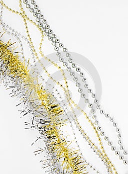 Diagonal. Silver and golden chain with balls, beads, yellow tinsel. New year decorations on a white background. Christmas concept.