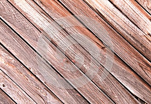 Diagonal slanted barn wall siding boards weathered faded and worn as an interior or exterior design architectural scene