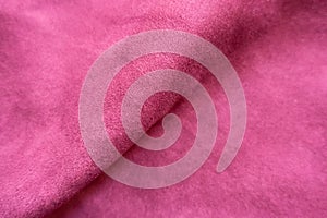 Diagonal soft fold on cerise-colored faux suede fabric