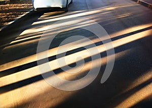 Diagonal sun beams on street asphalt backdrop