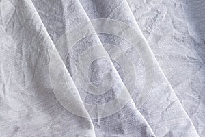 Diagonal textural background of natural linen fabric. Rough crumpled burlap texture