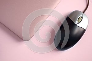 Diagonal View of Pink Toned Laptop and Mouse on White Background