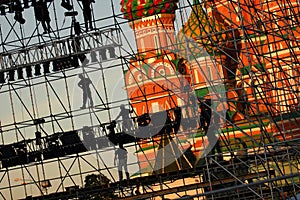 Diagonal view on workers on stage construction levels at Moscow Red Square in front of Vasiliy Blazhenniy Cathedral. Workers shado