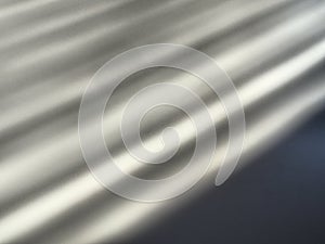 Diagonal white rays of light on gray background. Blurred abstract backdrop light effect, leaks, beams. Side surface