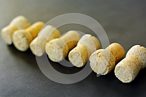 Diagonally lined seven sparkling wine corks on black background.