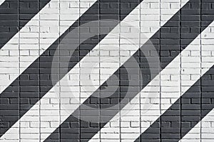 Diagonally painted bricks surface of wall in black and white color, as graffiti. Graphic grunge texture of wall