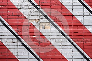 Diagonally painted bricks surface of wall in red, black and white colors, as graffiti. Graphic grunge texture of wall